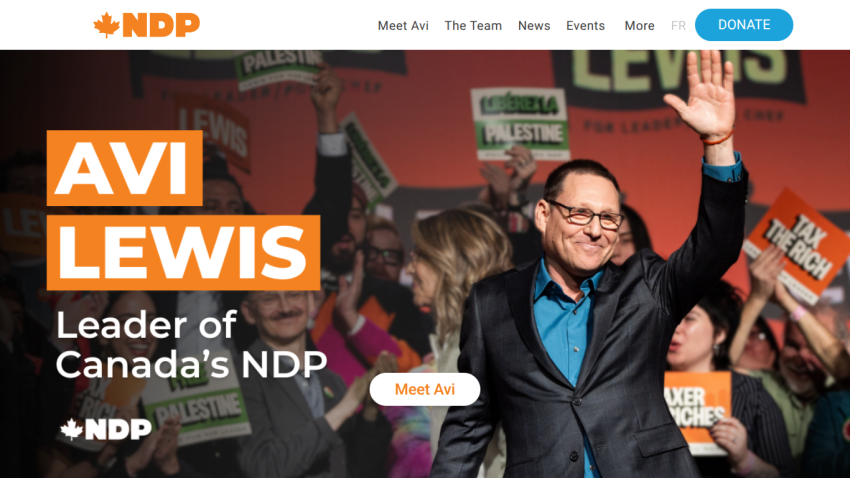 Avi Lewis, Leader of Canada's NDP, waving at an event with supporters in the background.