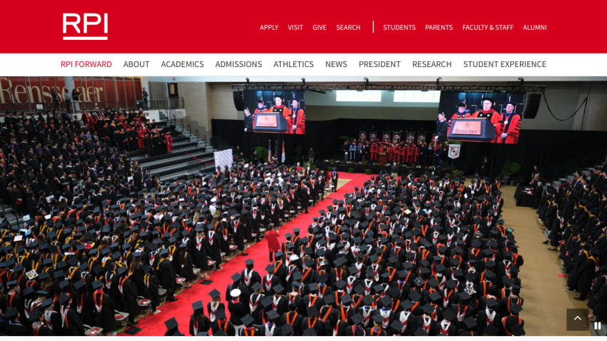 Graduation ceremony at RPI with graduates in caps and gowns on a red carpet.