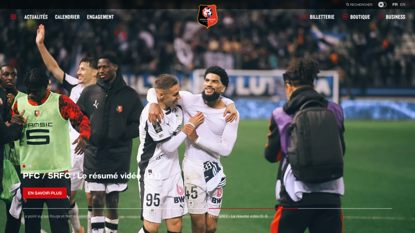 Football players celebrating on the field with score and match details overlay