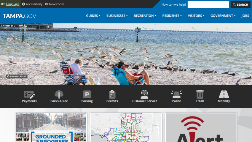 Tampa.gov homepage featuring beach scene, navigation links, and alert notification.