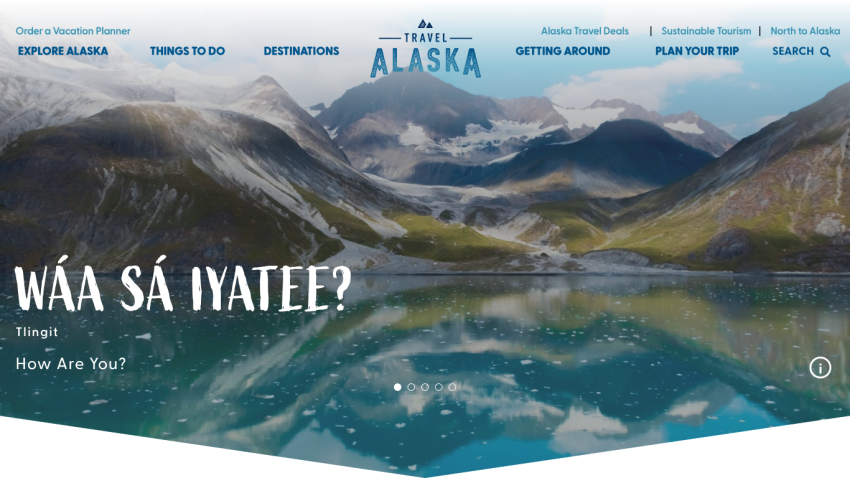 Homepage of Travel Alaska featuring a scenic landscape and greeting in native language.