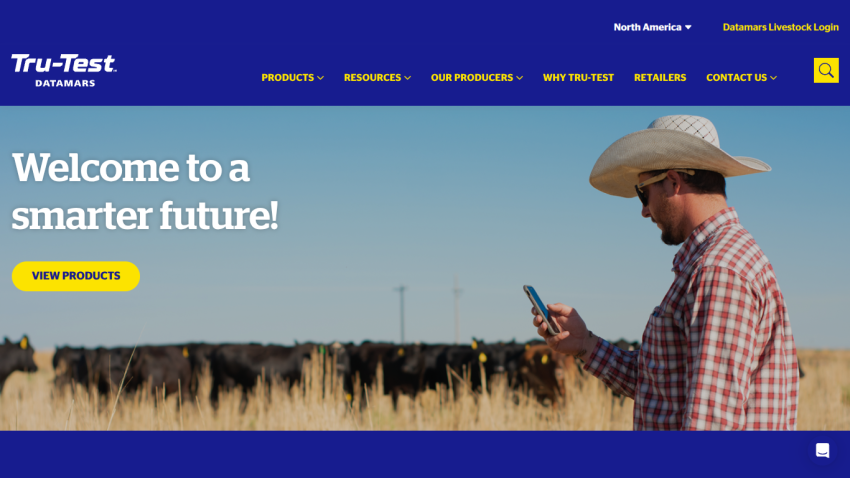 Homepage with navigation menu and hero section featuring a man in a cowboy hat using a phone in a field with cattle, welcoming to a smarter future