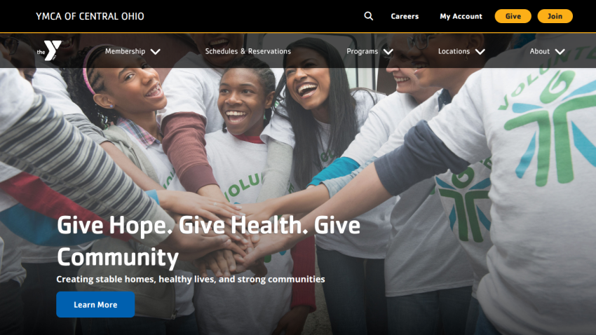 YMCA of Central Ohio homepage with navigation and a volunteer group photo with text about giving hope, health, and community
