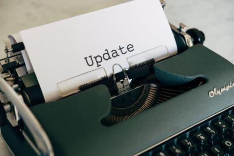 A sheet reading update is being typed in a typewriter