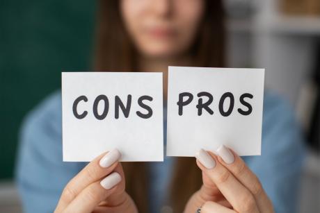 Blurry woman holds pros and cons post-its