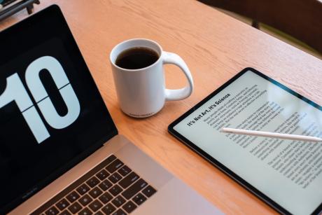 A laptop, a tablet and a coffee cup on the table