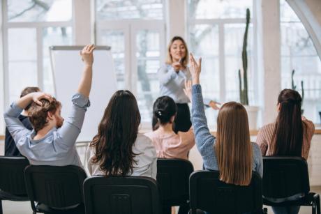 Female speaker giving presentation in hall at university workshop.