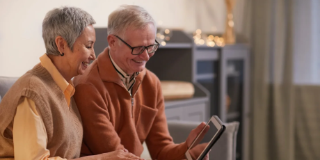 an old couple looking at an ipad