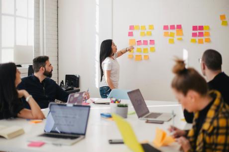 Woman pointing at sticky notes on the board