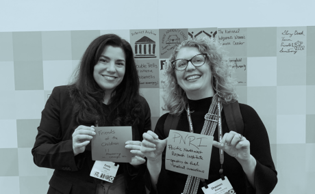 two women standing holding placard