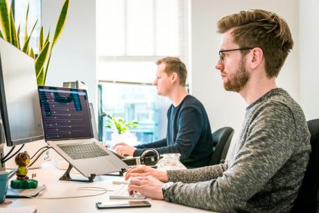 man-sitting-on-chair-wearing-gray-crew-neck-long-sleeved-shirt-using-apple-magic-keyboard