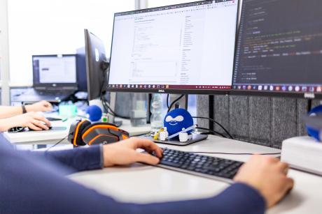 A developer working on a workstation withing codeblock. A Drupal themed blue softball is seen in the table.