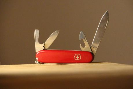 A swiss army knife on a wooden table. Photo:  Denise Jans