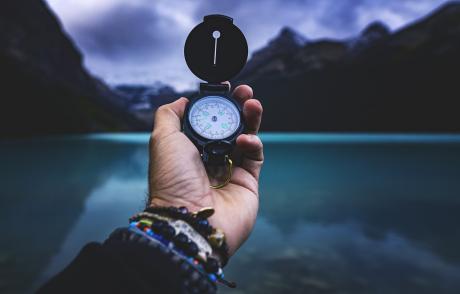 a hand holding a compass