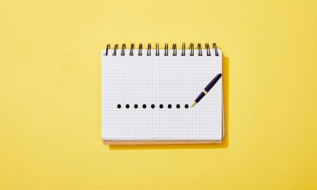 a pen marking dots on a notepad