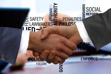 two hands of professionals shaking hands and different values in connection with governance