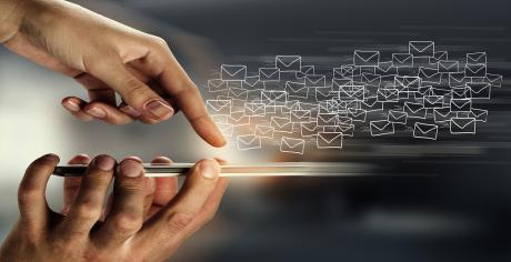 A finger touching a phone and lots of envelopes  flying away