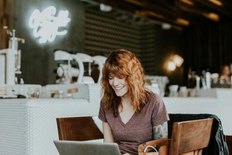 happy woman sitting infront of a laptop