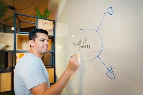 Man writing Marketing Strategy on White board