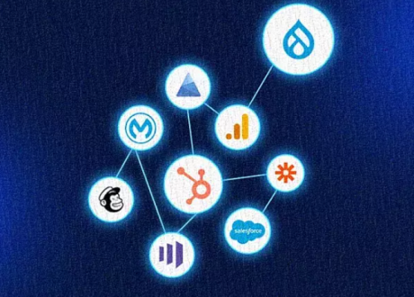 Network diagram featuring the HubSpot sprocket logo at center connected by lines to service icons for Drupal (water droplet), Google Analytics (bar chart), Zapier (asterisk), Salesforce (cloud), Mailchimp (chimp face), Mautic (stylized “M”), Microsoft Azure (triangle), and a three-bar metrics logo.