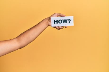 Hand of caucasian man holding paper with how word over isolated white background