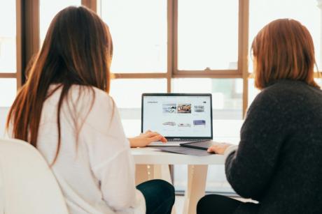 two ladies looking at a laptop screen