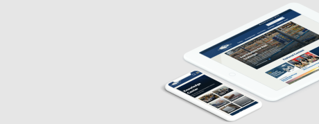 A white tablet and smartphone display responsive industrial company webpages with factory photography and a knowledge center layout. The devices sit on the right side of a light gray background with open space on the left.