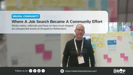 "DRUPAL COMMUNITY. Where A Job Search Became A Community Effort. Sticky notes. referrals and face to face trust shaped an unexpected scene at DrupalCon Rotterdam. Follow us on. https www.thedroptimes.com. THE DROP TIMES." A conference attendee wearing a Rotterdam shirt and event badge stands beside a community noticeboard covered with handwritten job postings and colorful sticky notes.