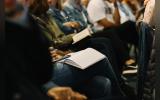 A photo from Victory Church, Jeffreys Bay, South Africa, where devotees are attending a sermon with notebooks and bibles in their hands.