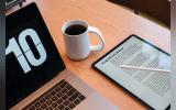 A laptop, a tablet and a coffee cup on the table