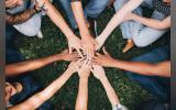 people stacking hands together in the park