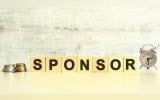 seven wooden cubes with letters on the table next to the coins. sponsor word.