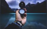a hand holding a compass