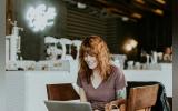 happy woman sitting infront of a laptop