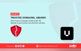 A pale blue security graphic uses a cracked red shield and a black square with a white U symbol to illustrate abuse of trusted websites. The graphic text reads "SECURITY" "TRUSTED DOMAINS, ABUSED" "Search spam campaigns exploit public file uploads on government and education websites." "Follow us on" "https://www.thedroptimes.com/" and "THE DROP TIMES".
