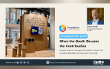 Acquia's cardboard exhibition booth at DrupalCon Rotterdam with a handwritten message stating that the company spent less on the booth so it could give $50,000 to Drupal.